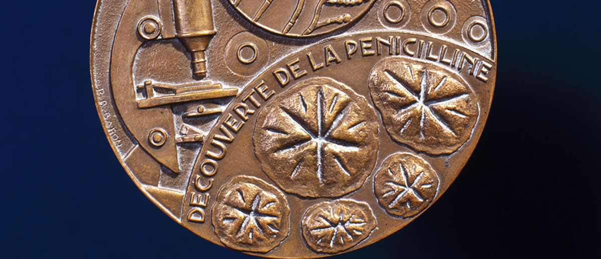 Image: An ornate bronze medal with the words ‘Decouverte de la Penicilline’ embossed on it. Other scientific motifs, including a microscope and a penicillin bacterium, are also featured on the medal