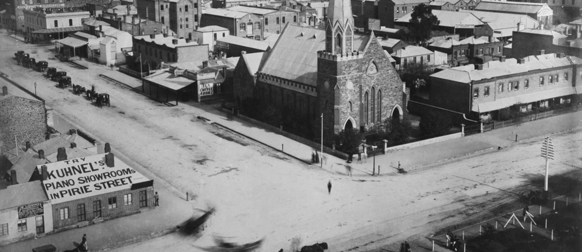 Image: aerial view of stone church with large steeple on street corner