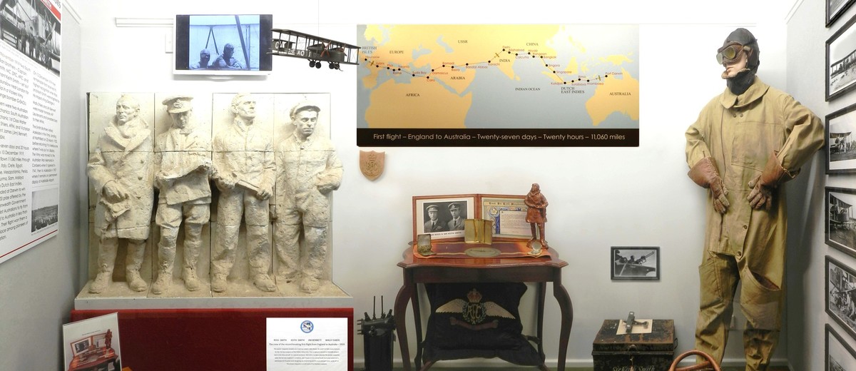 Image: display featuring map, manequin in flight gear and statue of four men