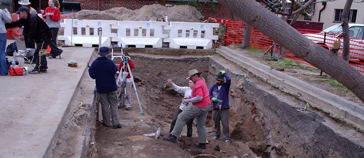Image: large hole in the ground with people standing in the bottom and above