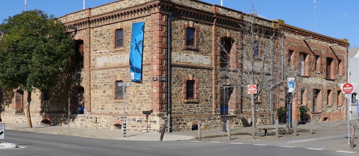 Image: Large stone building on corner with blue banner on closest wall. 