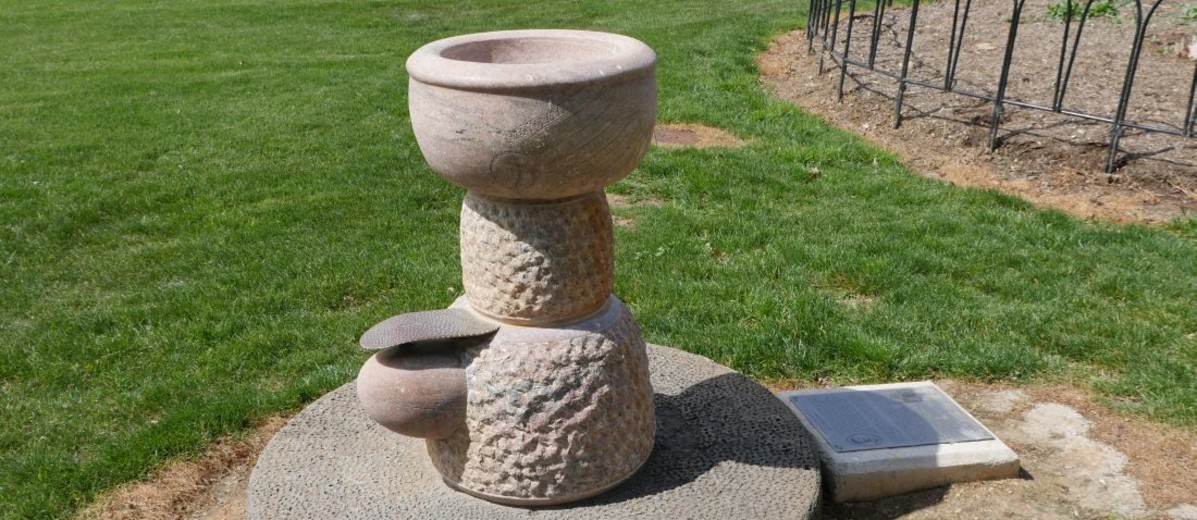 Marble drinking fountain with lawn in the background
