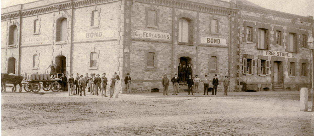 Image: group of men standing in front of large stone building