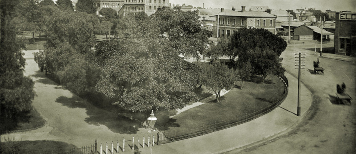 Image: View of city garden square with carts driving around 