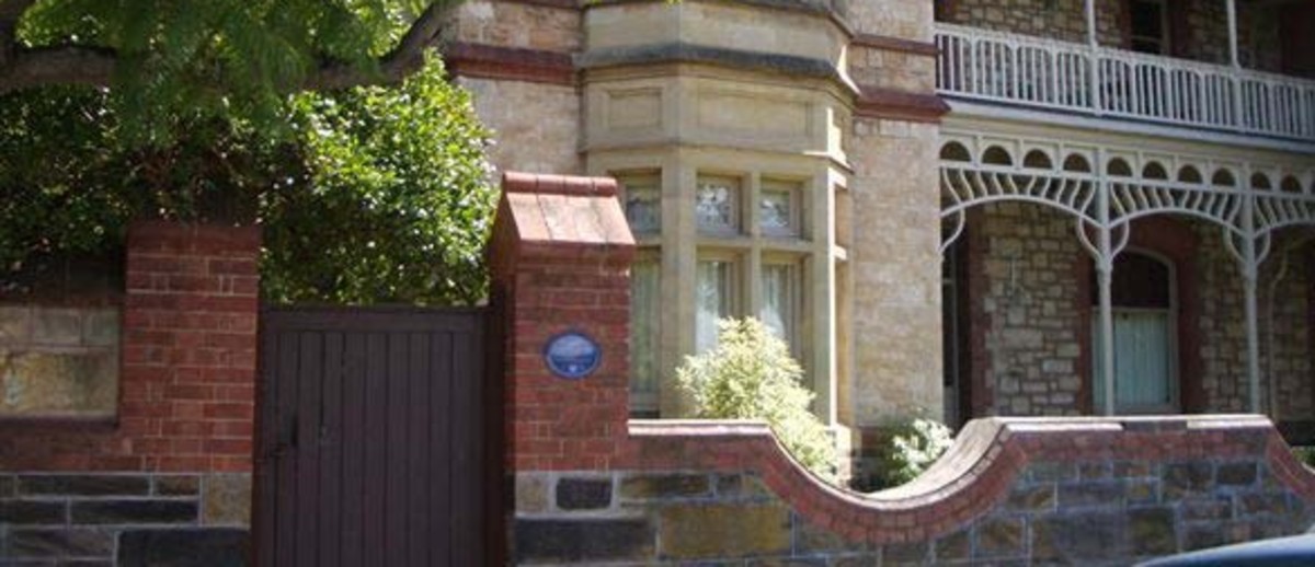 Image: Old stone building with blue plaque on the brick wall outside