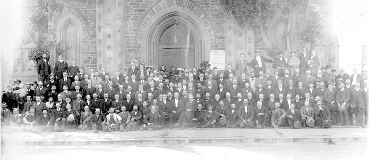 Image: crowd of congregation sitting in front of church facade and doorway