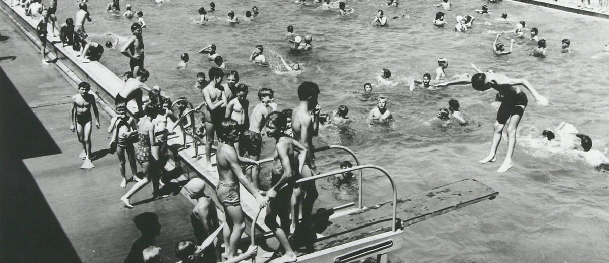 Image: large number of children in and around swimming pool
