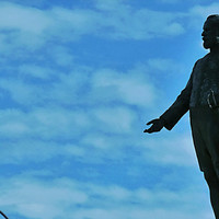 Image: sculpture of standing man silhouetted in sky