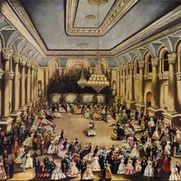 Image: couples in 1860s dress (the women's' gowns in a range of colours and the men mostly in black) dance in a large ballroom with columns lining the walls and large chandeliers hanging from the tray ceiling. 
