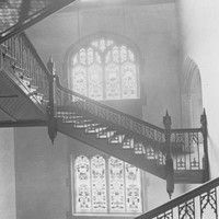 Image: A staircase with intricate windows in the background