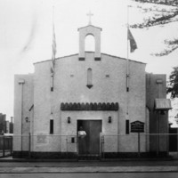Image: street view of a white stone church flying Greek and Australian flags.