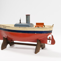 Image: toy boat made of metal and painted red, blue and cream
