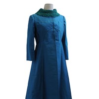 Image: peacock blue sparkling coat, long sleeves and skirt