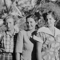 Image: A group of young Caucasian women flanked by two middle-aged Caucasian women pose for a photograph in rural central Australia. All of the women are wearing dresses of 1940s and 1950s vintage