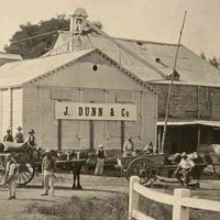Image: men and horse drawn carts in front of flour mill with J Dunn and Co sign