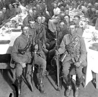 Image: large group of men in army uniform seated at tables in hall