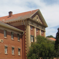 Image: A vey large, three-storey historic brick building with a neo-Classical entry. Two signs with the words ‘Ranson Mortlock Laboratory’ and ‘John Darling Laboratory’ are visible on the side of the building