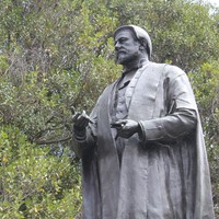Bronze statue of standing man wearing robes