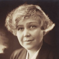 Image: A photographic head-and-shoulders portrait of an incredibly attractive young woman with light-coloured eyes and an ear-length 1920s haircut