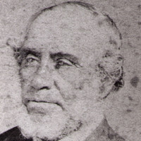 Image: A faded head-and-shoulders photographic portrait of an elderly man with thinning hair and a chin-beard