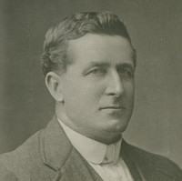 Image: Photographic portrait of a man in a suit jacket, vest and shirt. 
