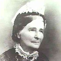 Image: A photographic head-and-shoulders portrait of a middle-aged woman in Victorian attire