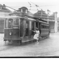 Image: woman standing on step of electric tram