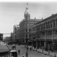 Image: black and white photo of street lined with three and four storey buildings