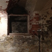 Image: interior of brick building, walls and cavity with large candle stand in foreground