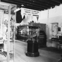 Black and white image of old museum display showing large wooden plinth with staircase on top. 