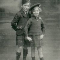 Image: boy and girl in tartan kilts and caps