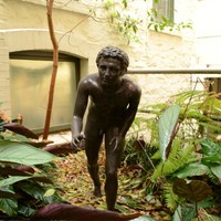Image: bronze statue of a young naked boy in running pose