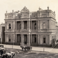 Image: horse carts and tram in front of ornate bank building