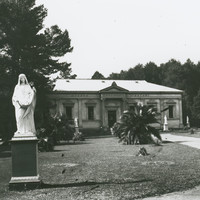 Image: statue of woman in front of tree and Greek Revival building