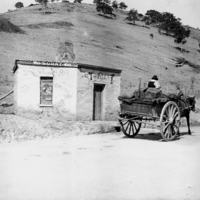 Image: Horse and cart in front of run-down toll house building