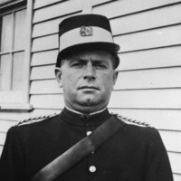 Image: A man in a police uniform with kepi cap and leather bandolier