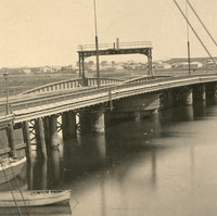 Image: A nineteenth-century swing bridge with centrally located turntable extends across a narrow river. A number of small sailing craft are visible in the river next to the bridge