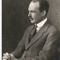 Image: side view of man in suit, seated