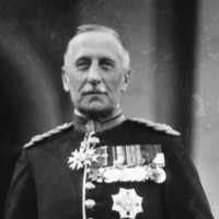 Image: A photographic portrait of a middle-aged Caucasian man wearing full military dress uniform including sword, plumed helmet and spurs. On his chest he wears an array of medals and orders