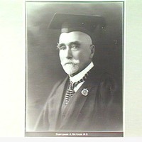 Image: black and white head shot of man wearing mortar board