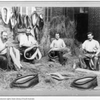 Image: group of men holding and making leather horse collars