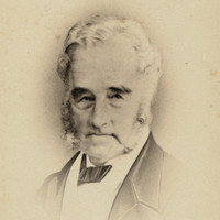 Image: Photographic head-and-shoulders portrait of an elderly Caucasian man in seven eighths view. His grey hair, sideburns and beard are neatly trimmed