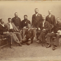 Image: nine men posing for a portrait, six are seated, four are standing