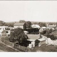 Panoramic view of the Anlaby homestead and surrounding structures and gardens. Two men are transferring hay from a horse drawn cart