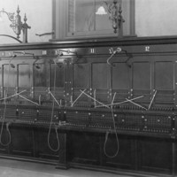 Image: An empty telephone exchange with a selection of switchboards
