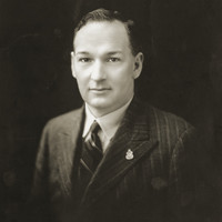 Image: Black and white portrait photograph of the upper body of a man dressed in formal attire