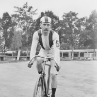 Image: cyclist wearing a cap and the number five on his forearm prepares for a race