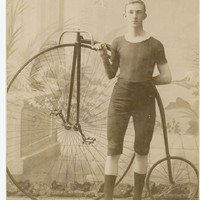 Image: young cyclist holding onto the handlebar of his penny-farthing bicycle