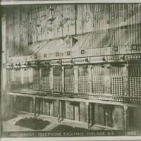 Image: Black and white photograph of a telephone exchange. There are no people present