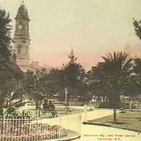 Image: Early coloured photograph of formal gardens with the Post Office tower visible in the background